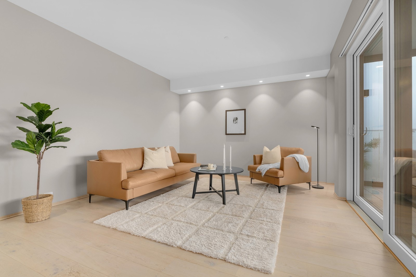 Lys og romslig stue med utgang til innglasset balkong med skyvedør Galleribilde