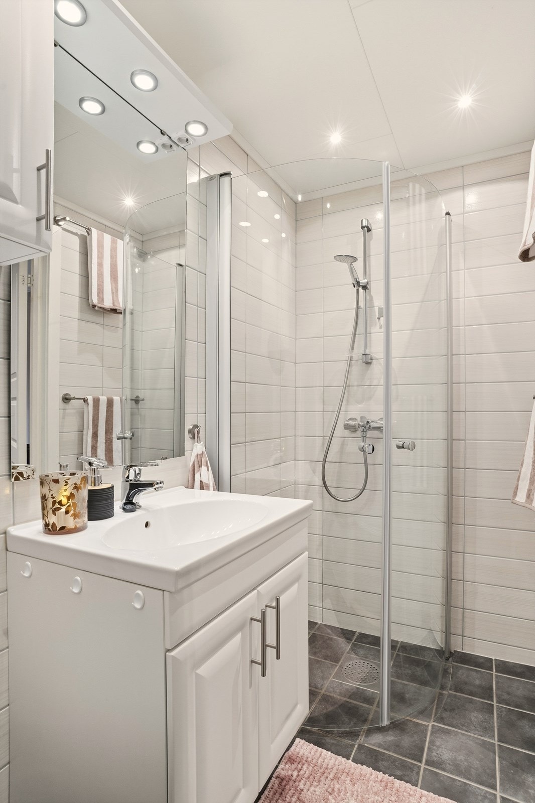 Badet inneholder servant med skap, speil, wc og dusjsone. Galleribilde