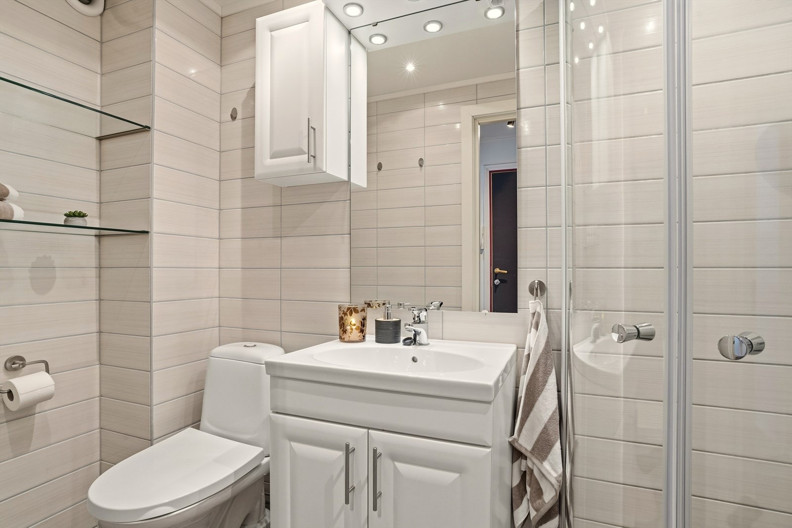 Delikat og lyst, flislagt baderom med varmekabler i gulv og downlights i tak som skaper den riktige belysningen på badet. Galleribilde