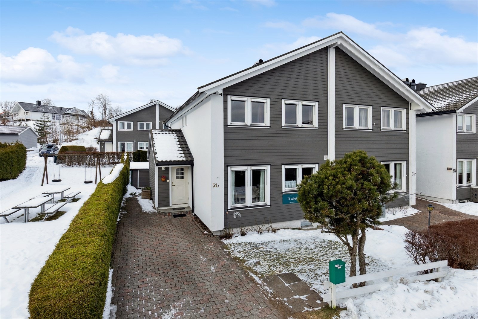 Gårdsplass med belegningsstein og garasje i felles rekke. Galleribilde