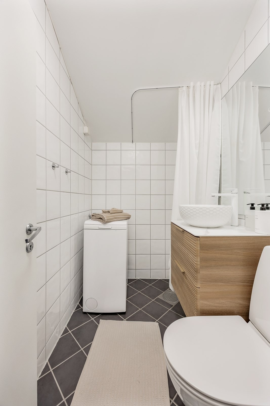 Rommet er utstyrt med vegghengt toalett og en stilren baderomsinnredning. Galleribilde