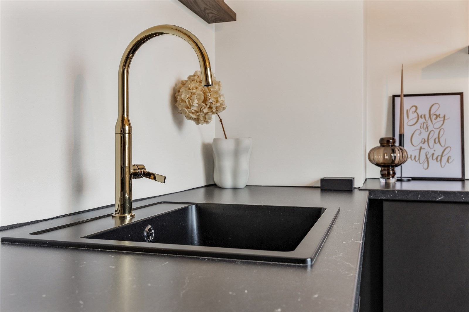 Moderne, underlimt vask og armatur i messingfinish setter et elegant preg. Galleribilde