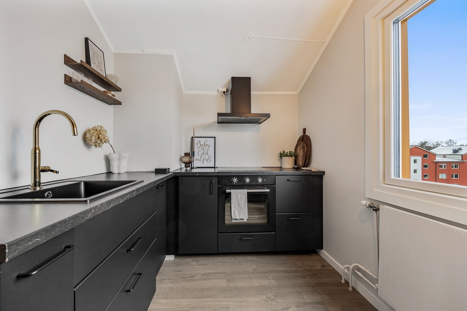 Leiligheten har et stilrent, mørkt kjøkken med god benkeplass. Galleribilde