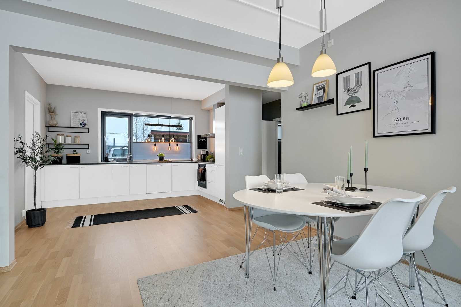 Kjøkkenet har en moderne utforming med hvit innredning og en benkeflate av god størrelse Galleribilde