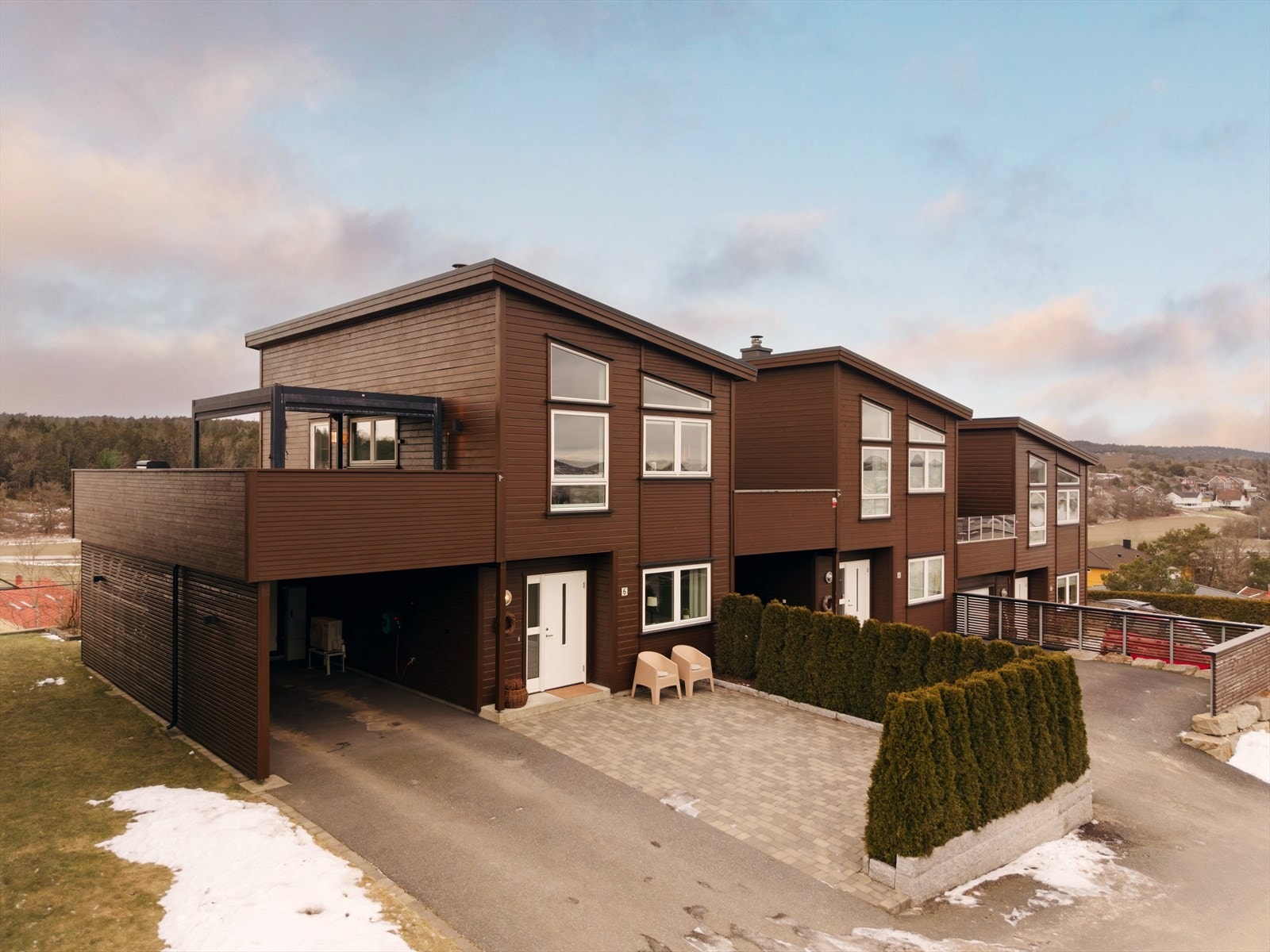 Til boligen hører en egen carport, praktisk integrert i bygningskroppen. Galleribilde