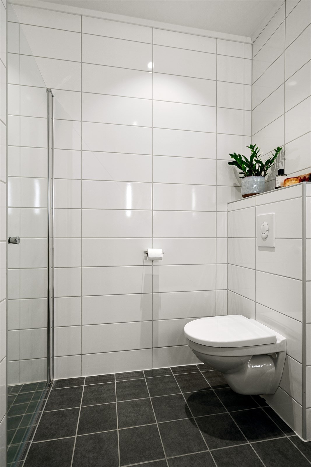 Badet har flislagt gulv med elektrisk gulvvarme, flislagte vegger og vegghengt toalett. Galleribilde