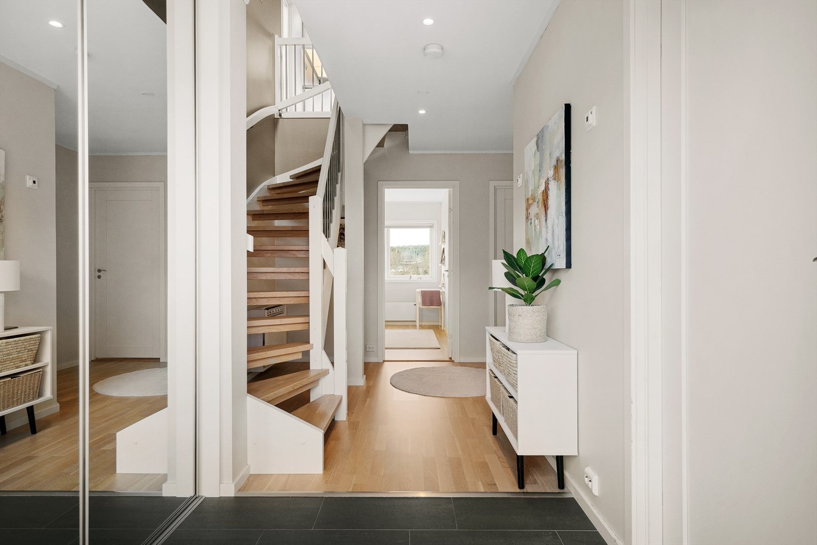 I første etasje ønskes du velkommen av en lys og innbydende entré med god oppbevaringsplass for sko og yttertøy i garderobeskap med speil-skyvedører. Galleribilde