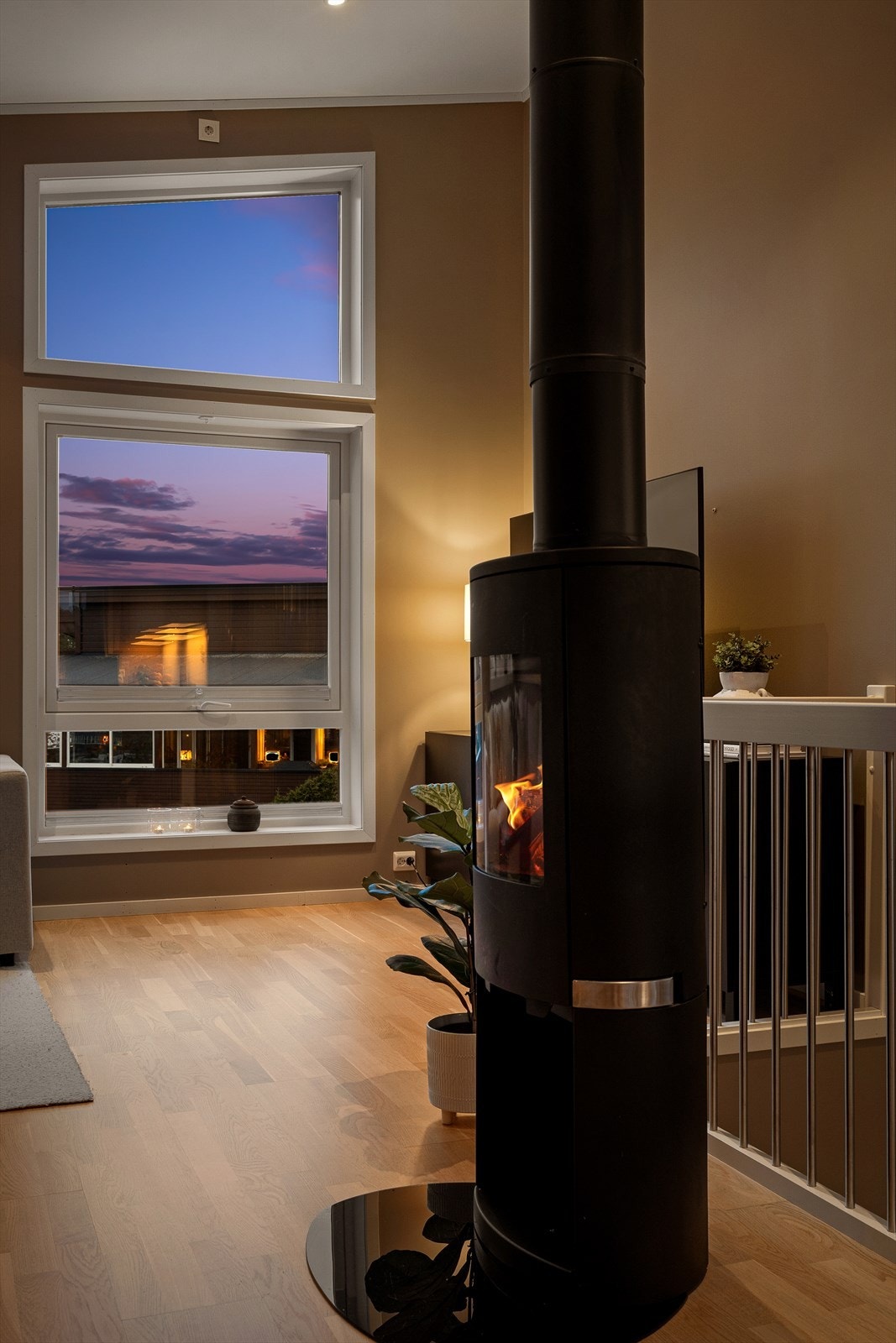 En sentralt plassert vedovn med stålpipe gir både effektiv varme og en hyggelig atmosfære. Galleribilde