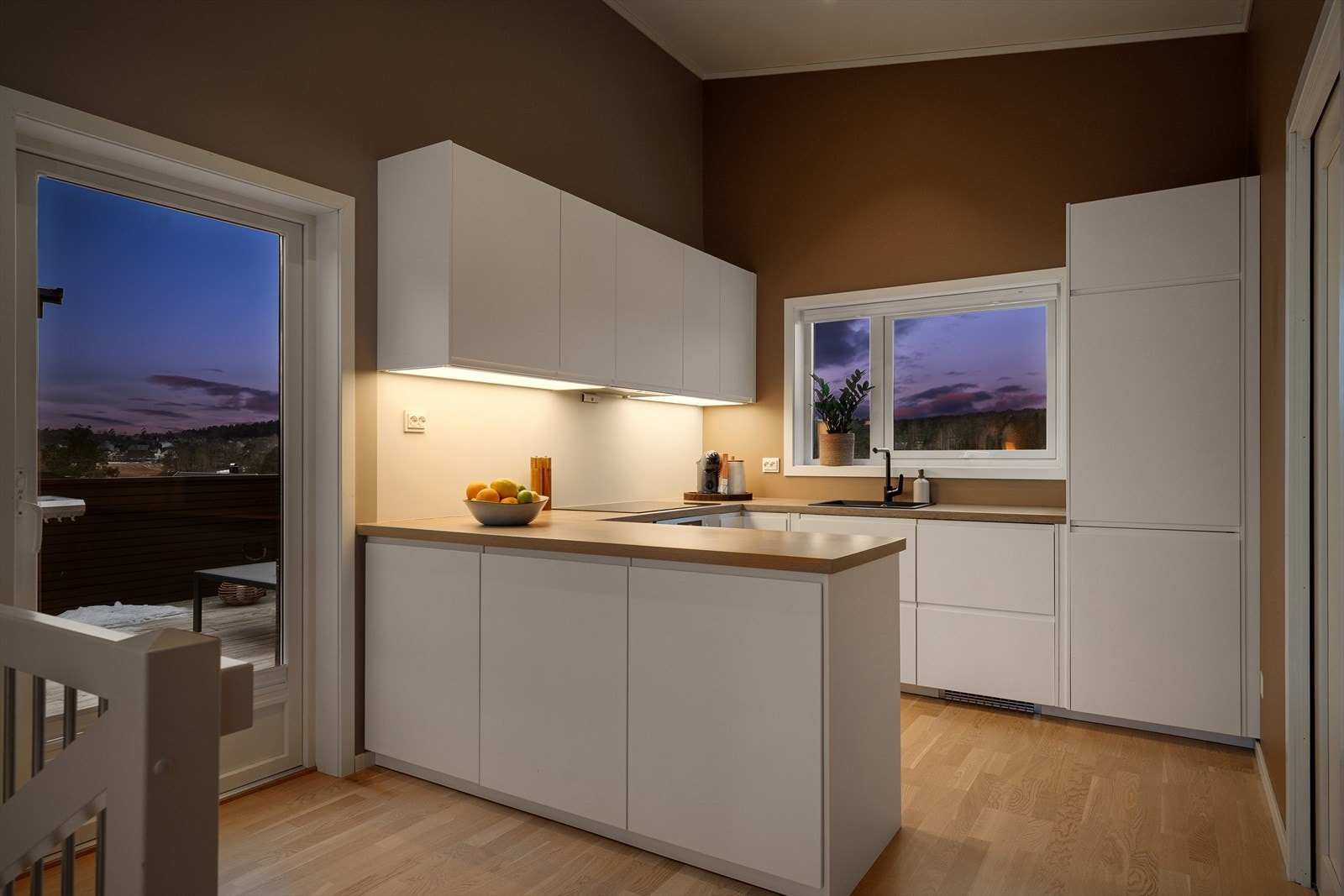 Kjøkkenet har en stilren og moderne innredning med glatte fronter og en praktisk laminatbenkeplate. Galleribilde