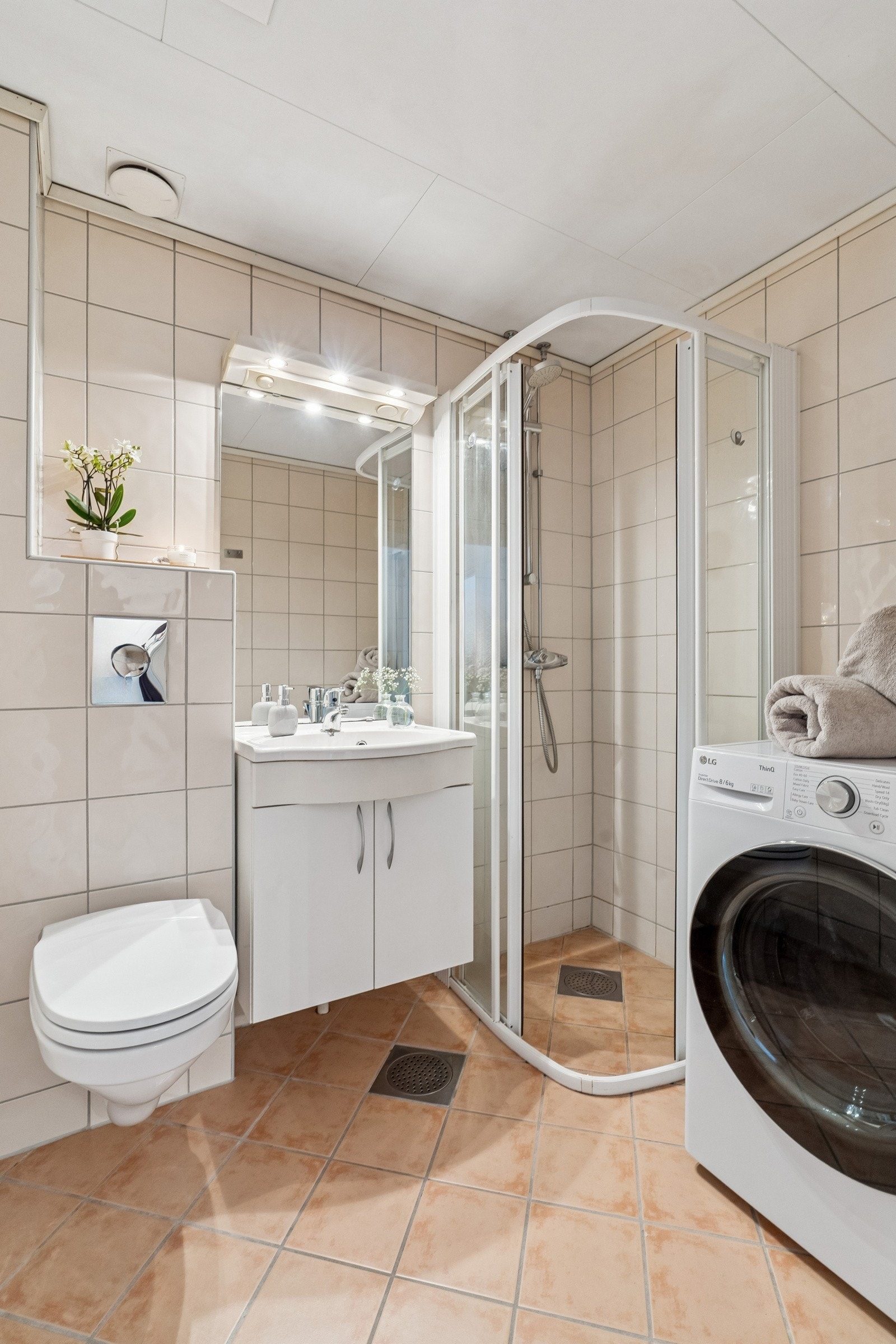 Flislagt bad innredet med dusjhjørne, servantskap, veggmontert toalett og opplegg for vaskemaskin. Pusset opp av borettslaget i 2005. Galleribilde