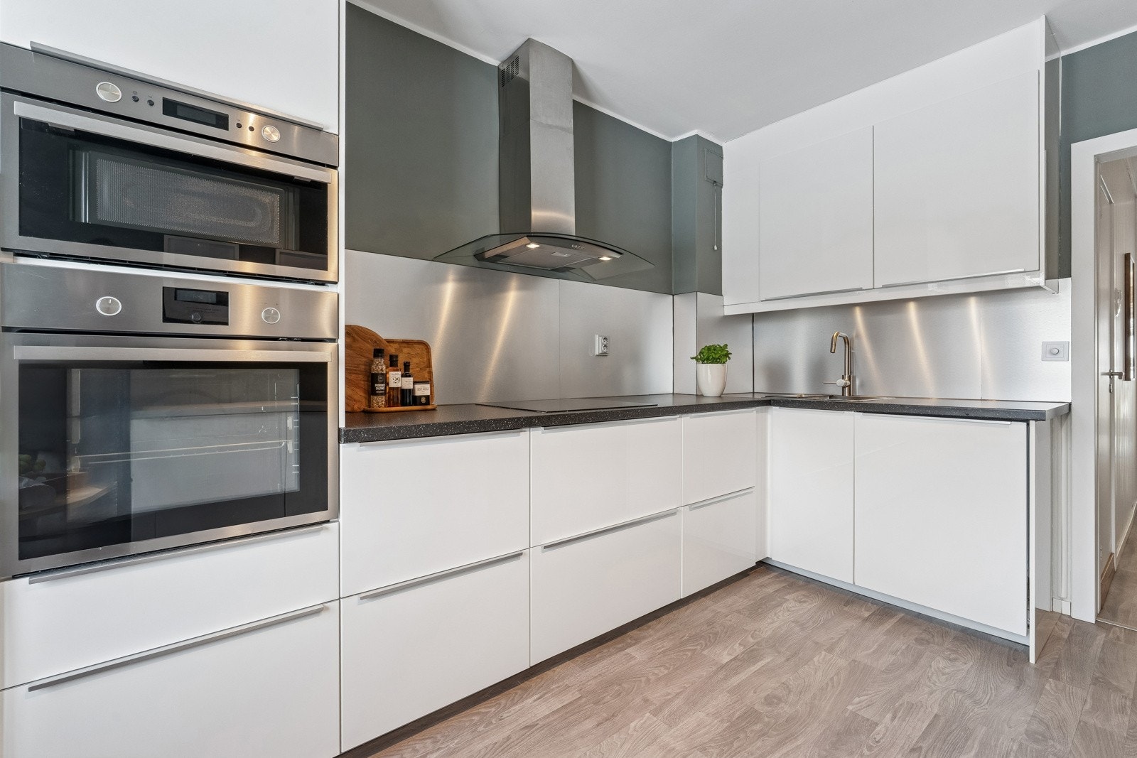 Takhøy kjøkkeninnredning med glatte, høyglans fronter. Galleribilde