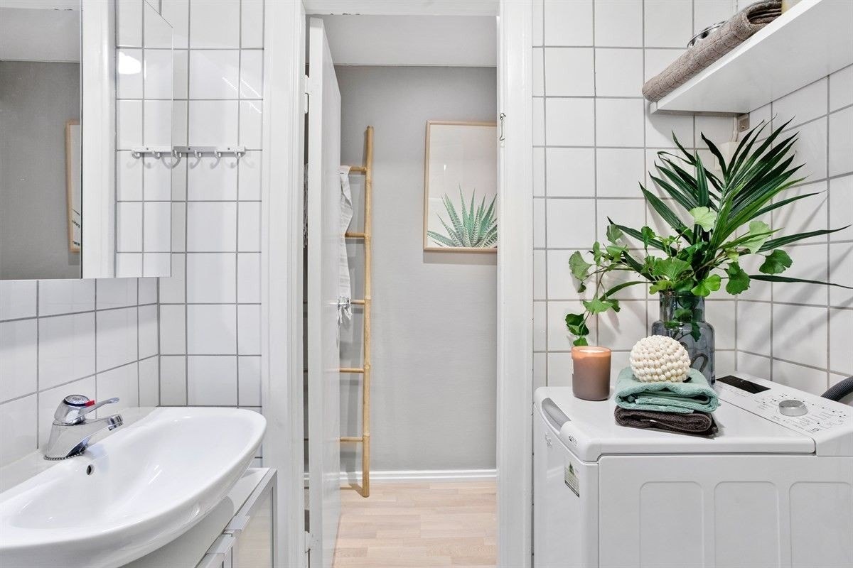 Pent, flislagt bad med vaskemaskin. Galleribilde