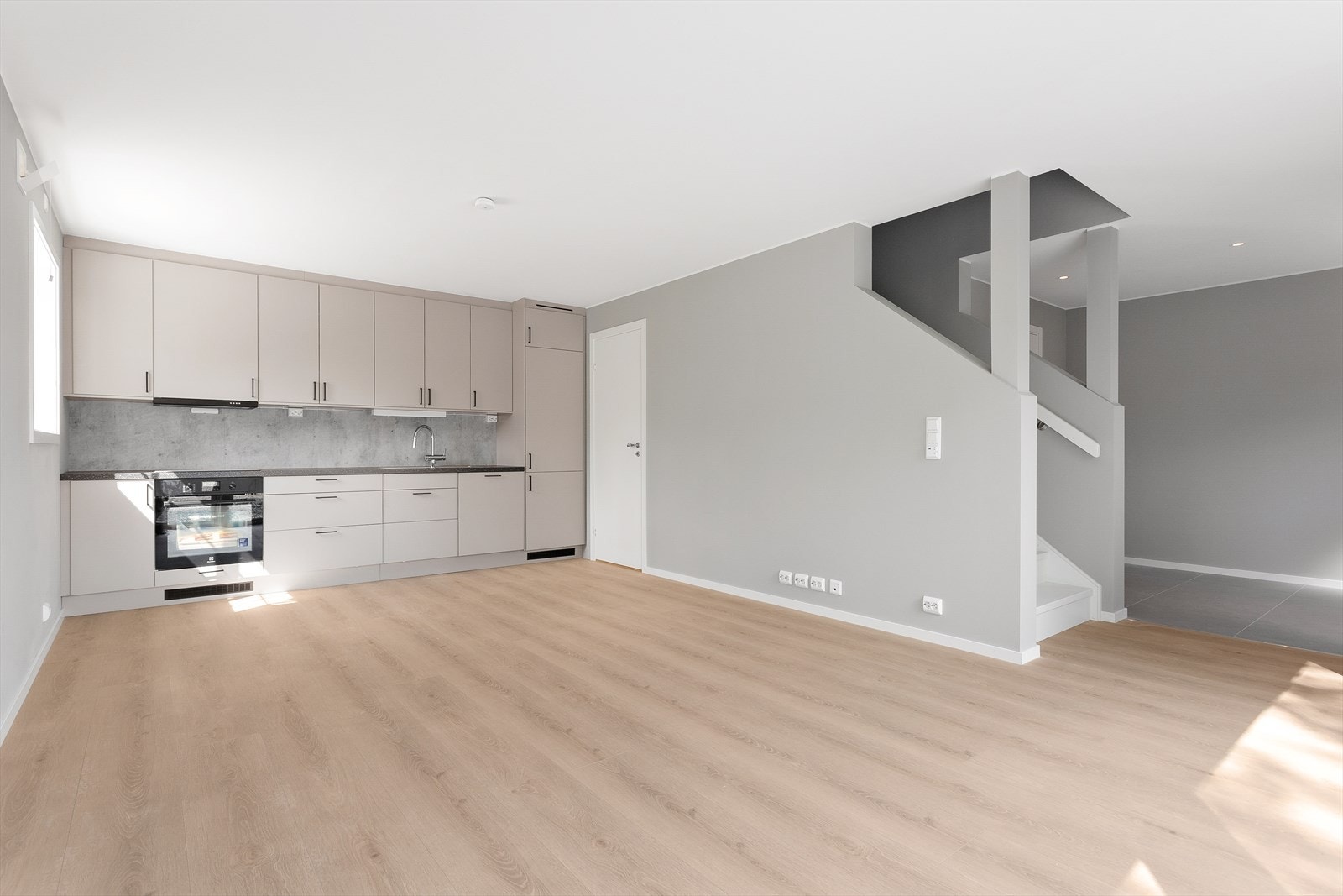 Det stilrene kjøkkenet er både funksjonelt og moderne, og glir pent inn som en del av allrommet. Galleribilde