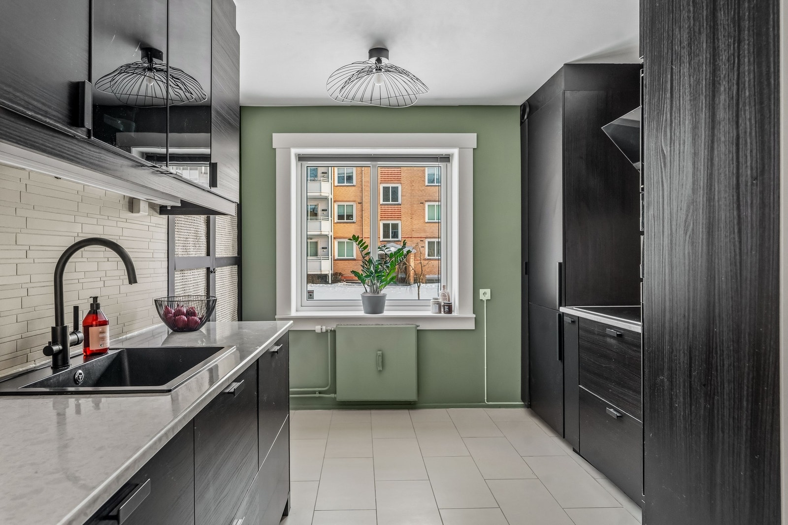 Kjøkkeninnredning fra Ikea fra ca 2016 iflg tidligere eier. Innredningen er med glatte fronter i sort, det er laminert benkeplate, ventilator over koketopp med kullfilter, og fliser mellom benk og overskap. Galleribilde