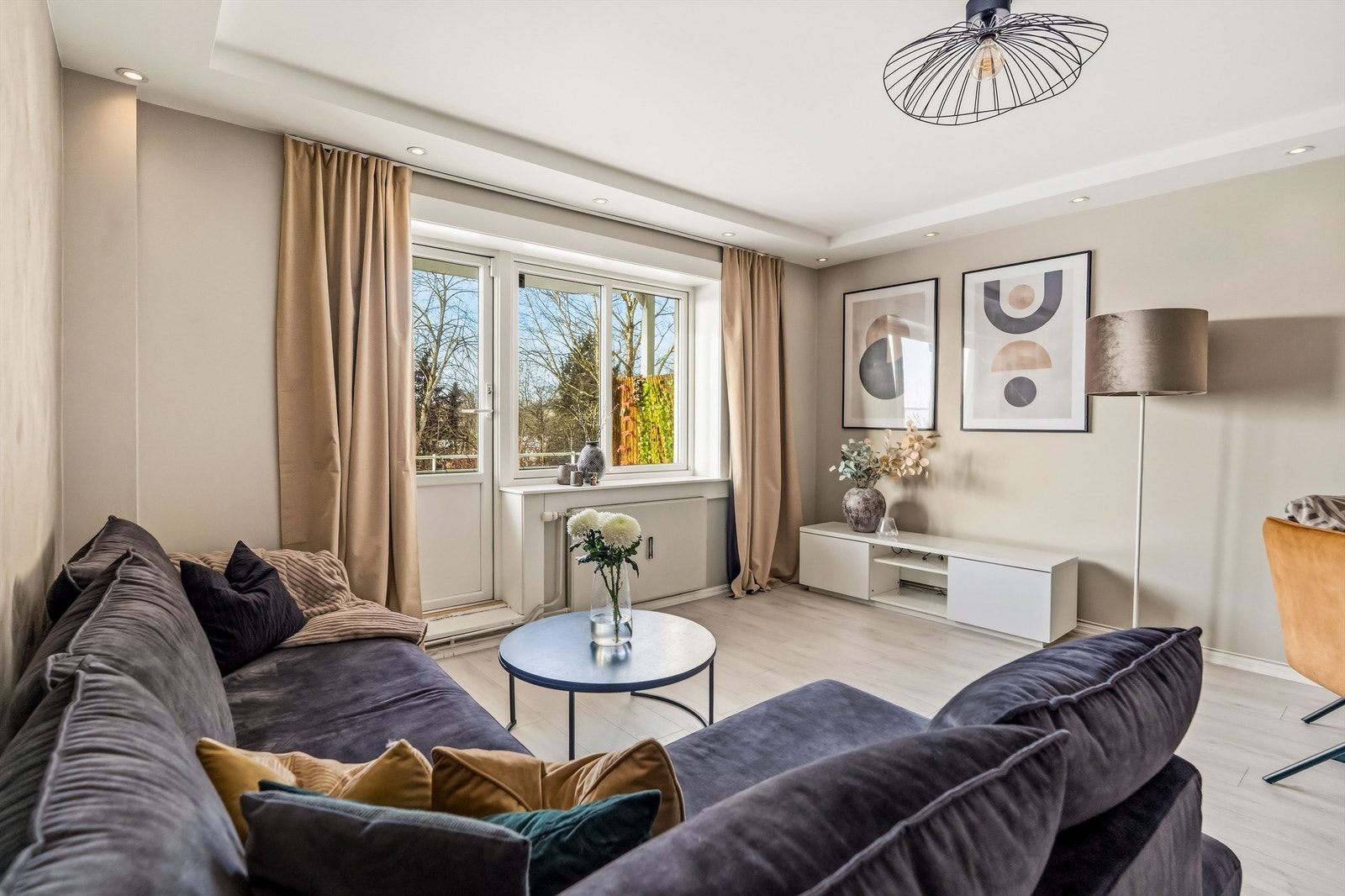 Stuen er lys og romslig med malte flater og downlights i nedsenket del av himlingen Galleribilde