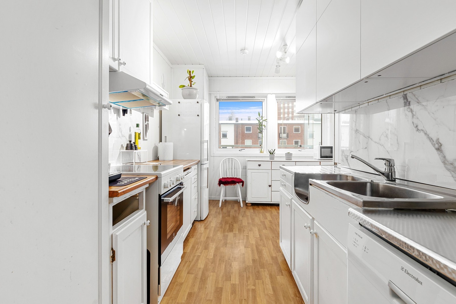 Kjøkkeninnredning med både glatte og profilerte fronter, samt benkeplate av laminat og stål Galleribilde