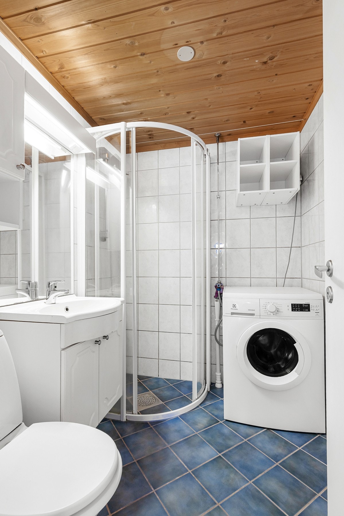 Rommet har innredning med nedfelt servant, toalett, dusjvegger/hjørne og opplegg for vaskemaskin Galleribilde