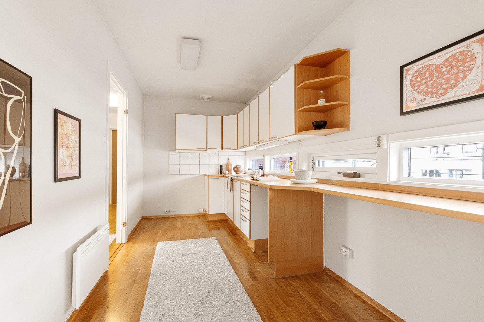 Eldre kjøkken med glatte fronter og laminat benkeplate med nedfelt oppvaskkum. Galleribilde