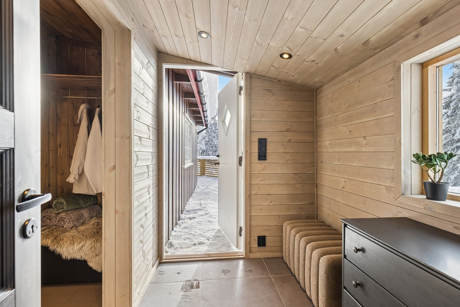 Entré med plass til sko og yttertøy. Det er fliser på gulv med gulvvarme og downlights i taket. Galleribilde