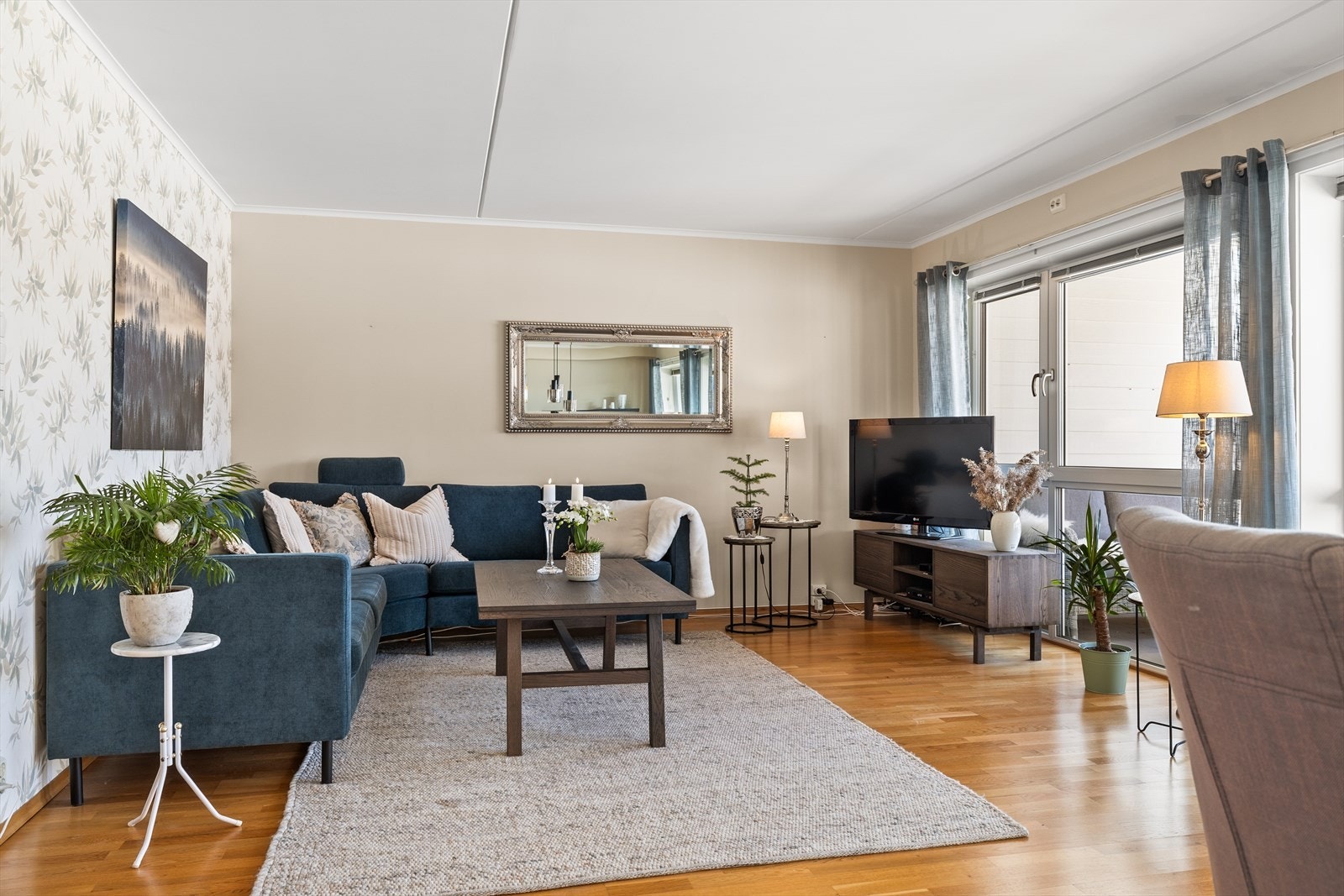 En dekorativ kontrastvegg med pen tapet tilfører rommet særpreg og dybde - et blikkfang som gir stuen det lille ekstra og løfter helhetsinntrykket. Galleribilde