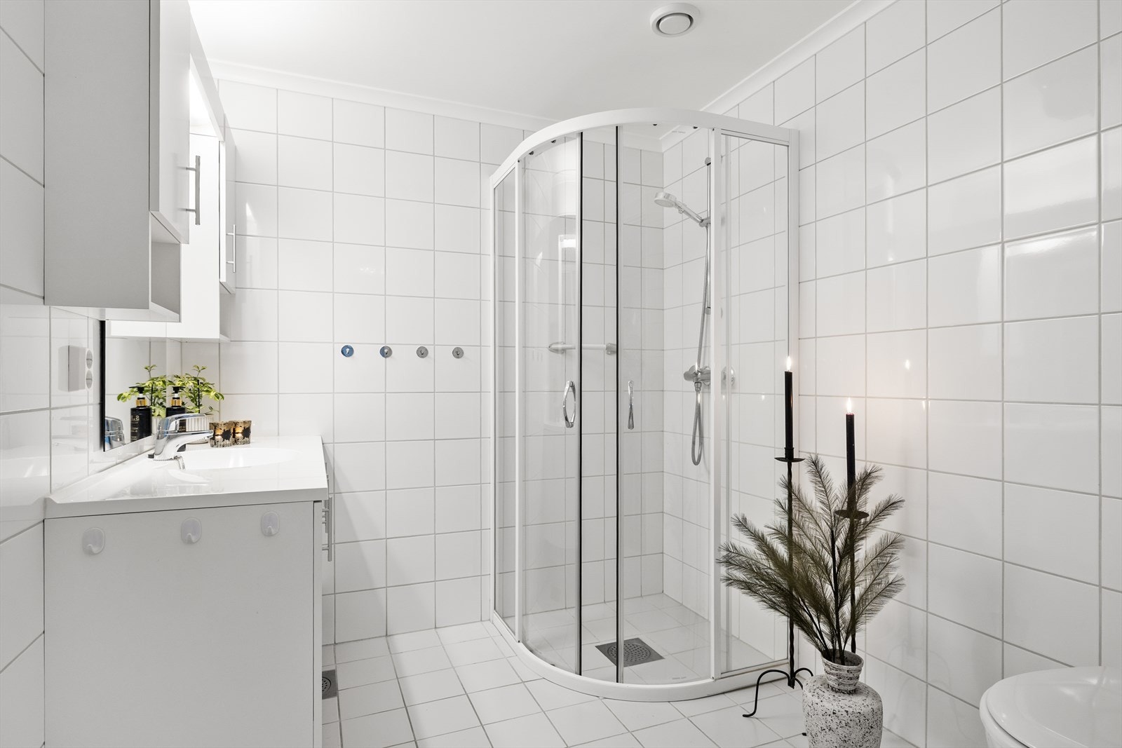 Baderommet fremstår lyst og pent med fliser på både gulv og vegger som gir et stilrent og tidløst uttrykk. På gulvet er det elektriske varmekabler som sørger for behagelig komfort året rundt - en detalj som virkelig merkes på kjølige morgener. Galleribilde