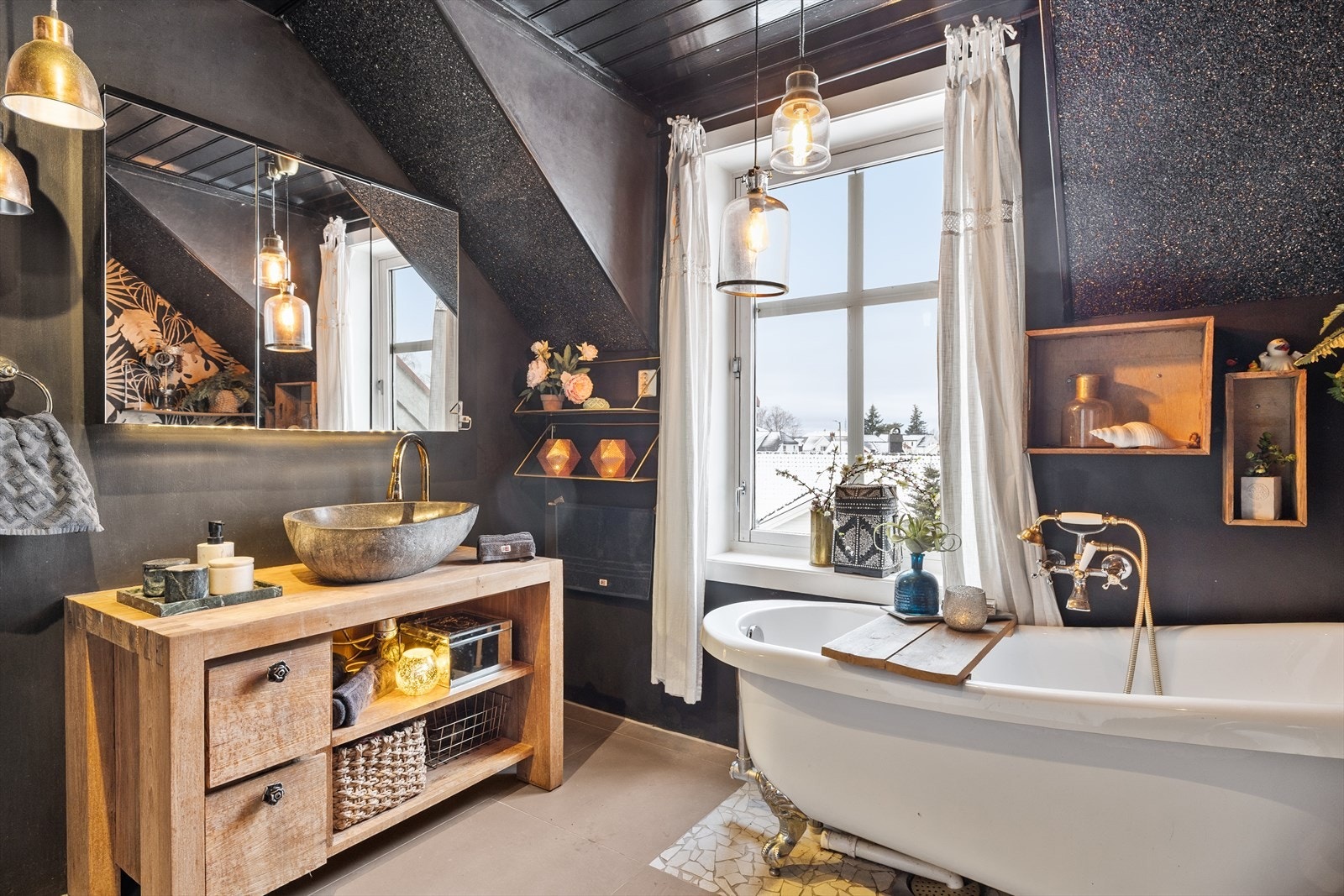 Baderommet har en praktisk og funksjonell utforming med fliser på veggene kombinert med tapet, samt trebelistning inn mot flisene i dusjens våtsone som gir et lunt preg. Gulvet er belagt med fliser og mosaikk som skaper et dekorativt og variert uttrykk. Galleribilde