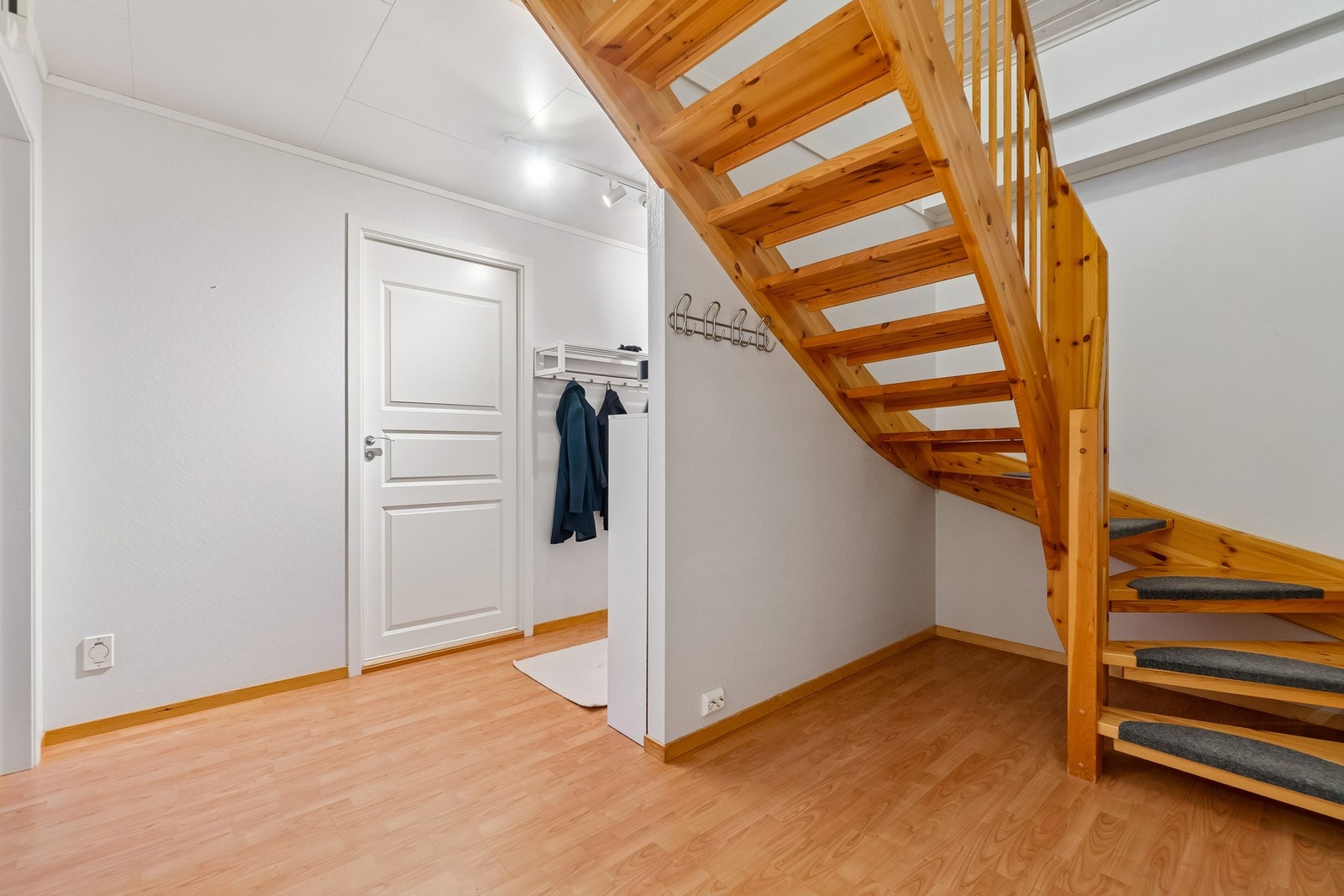 En luftig gang binder rommene i 1.etasje sammen, og her finner du trappen som tar deg videre opp til boligens andre etasje. Galleribilde