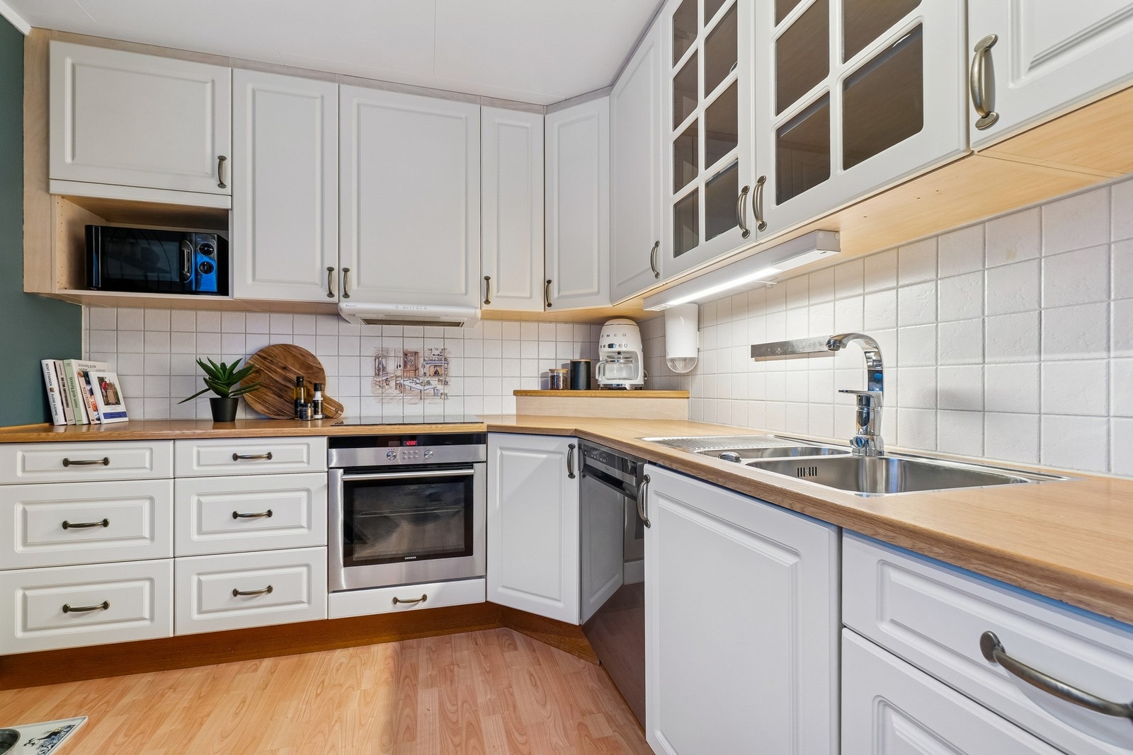 Kjøkkeninnredningen har tidløse fargekombinasjoner med lyse fronter og benkeplate i eik. Galleribilde