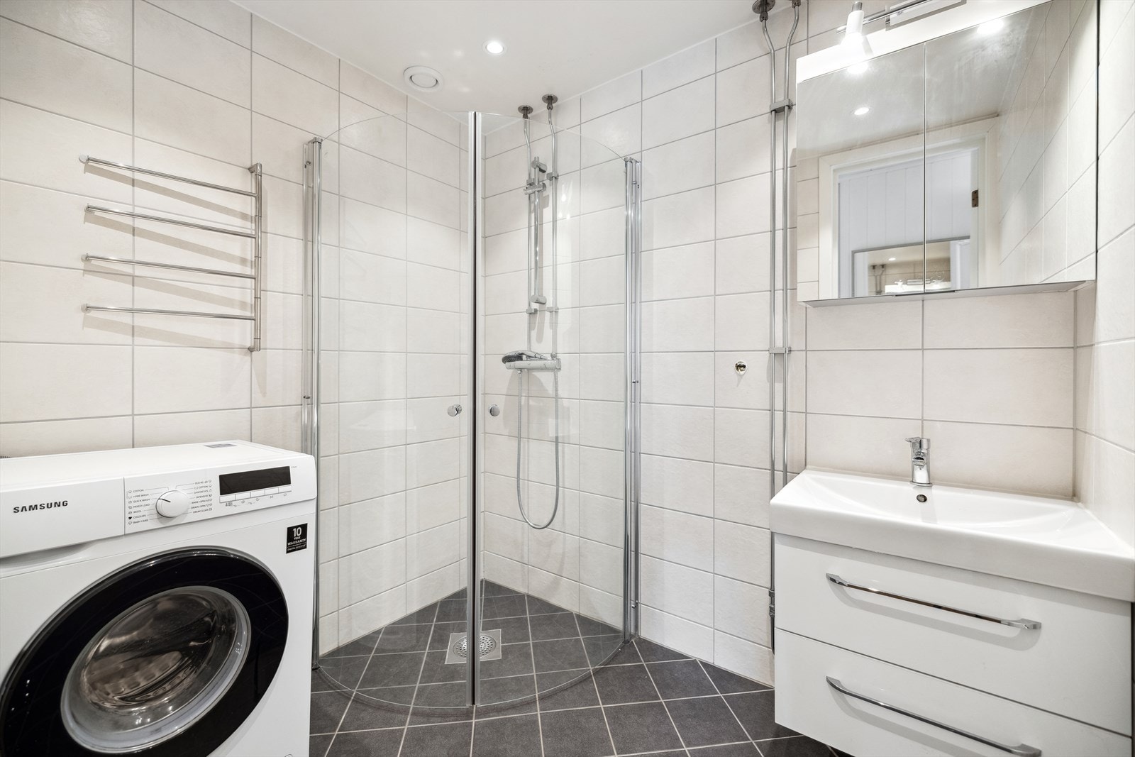 Bad med gulv og vegger med fliser, opplegg for vaskemaskin. Galleribilde