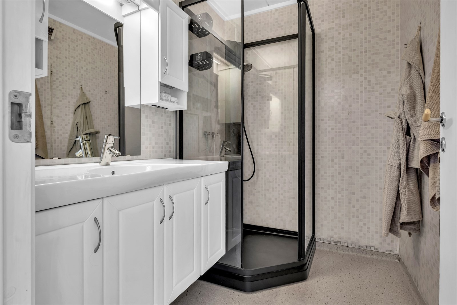 Baderom med dusjkabinett, servant, belysning og speil. Galleribilde