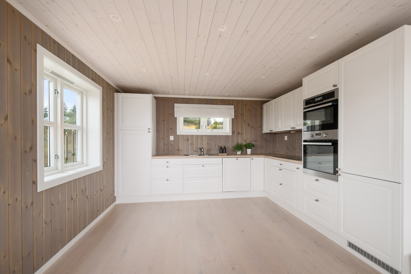 Lyst, romslig og praktisk kjøkken har innredning i L-form og rikelig med skapplass. Galleribilde