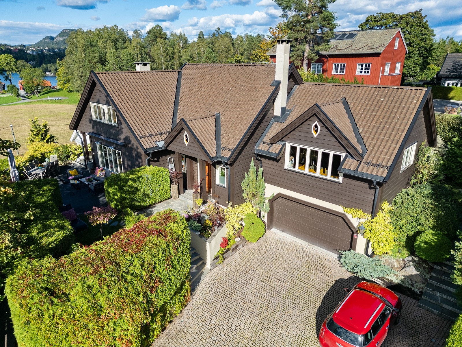 Flott opparbeidet eiendom med bl.a. gårdsplass og innkjørsel belagt med granitt brostein, nedsenket belysning og fin beplantning (bilde tatt sensommer 2025). Galleribilde