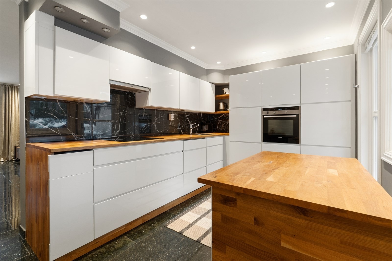 Kjøkkenet er fullt utstyrt med integrerte hvitevarer og rikelig med skap- og benkeplass. Galleribilde