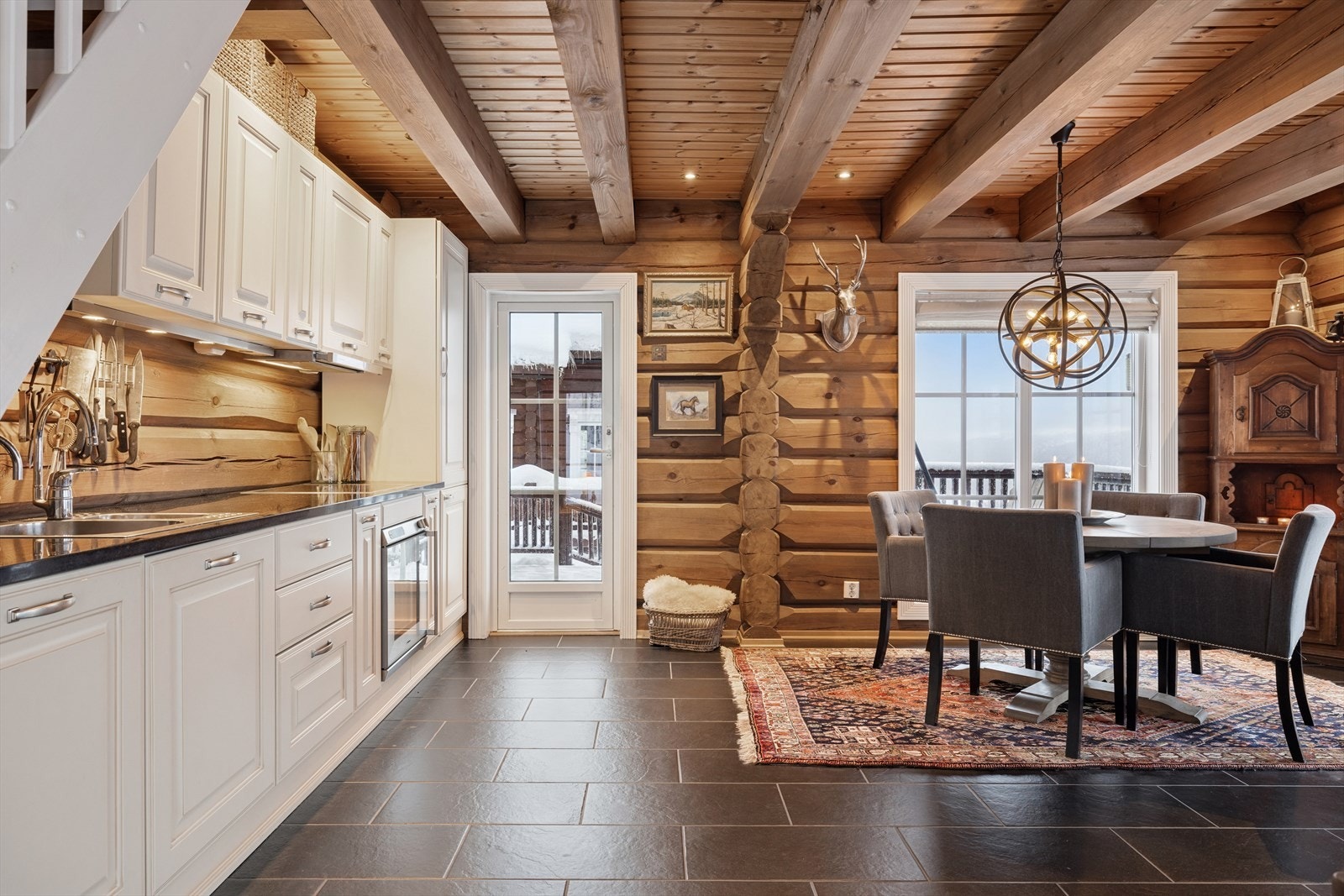 Kjøkkenet, opprinnelig fra 2011, har en klassisk og tidløs innredning med profilerte, lyse fronter og en eksklusiv benkeplate i stein/granitt Galleribilde