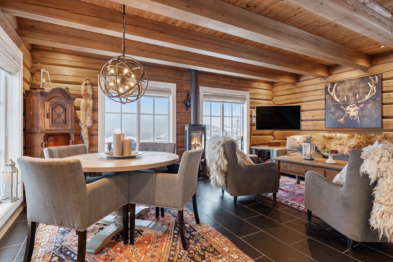 I boligens 1. etasje åpner stue og kjøkken seg i en praktfull, åpen løsning - et gjennomført stilfullt og sosialt oppholdsrom som umiddelbart gir en følelse av kvalitet Galleribilde