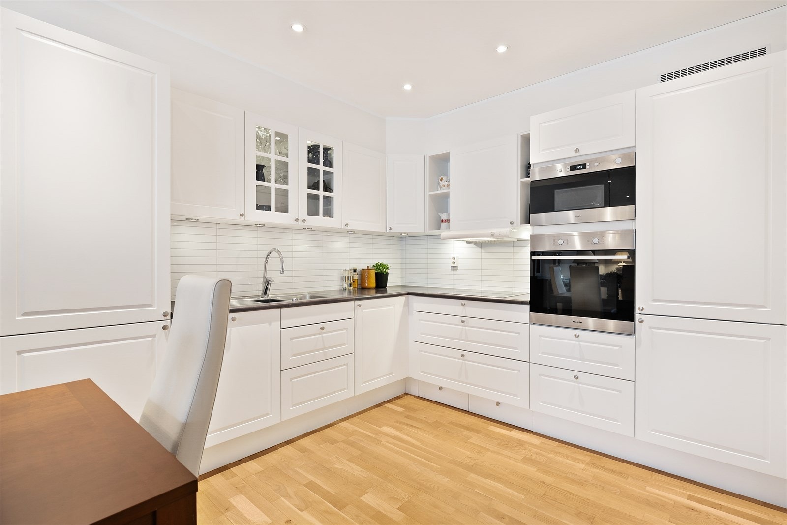 Kjøkken innredet med kjøl/fryseskap, platetopp, oppvaskmaskin, mikro og stekeovn Galleribilde