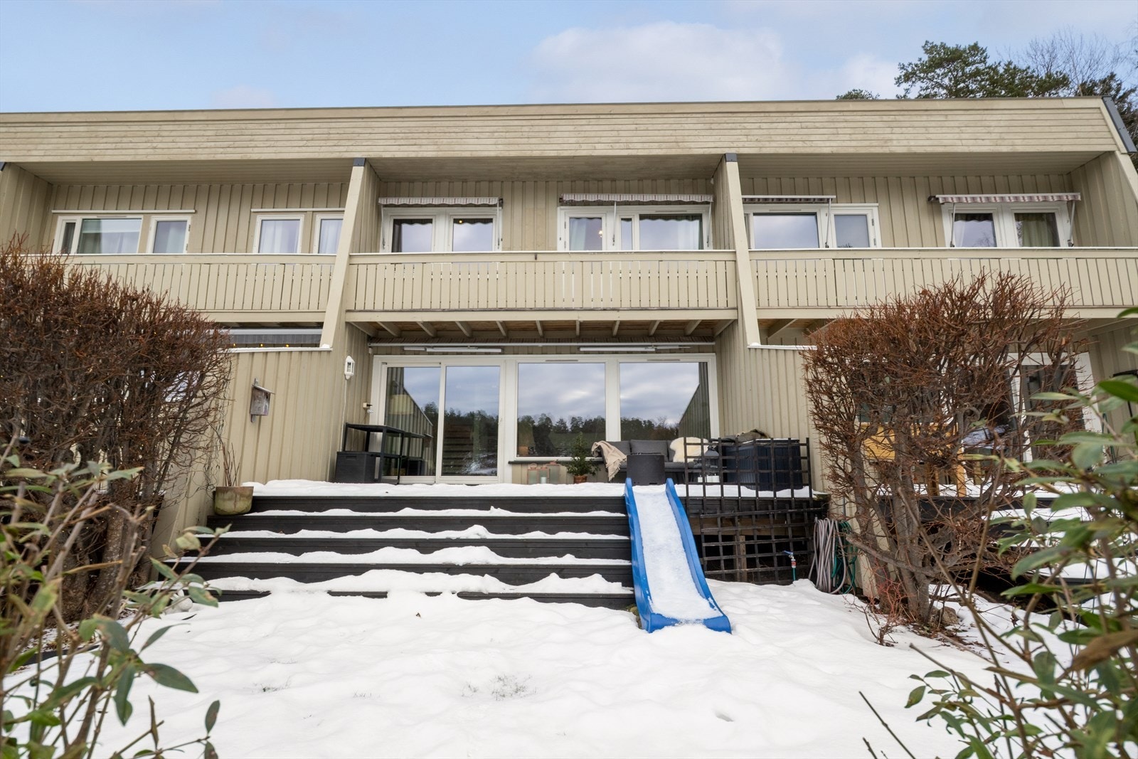 Tomten er opparbeidet med plen, prydbusker og hekk som skjermer uteplassene. Galleribilde