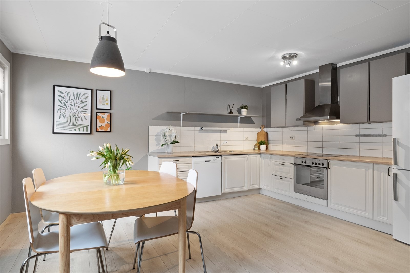 Klassisk kjøkkeninnredning med lyse profilerte fronter og benkeplate av laminat, kjøkkenet er fra Sigdal. Galleribilde