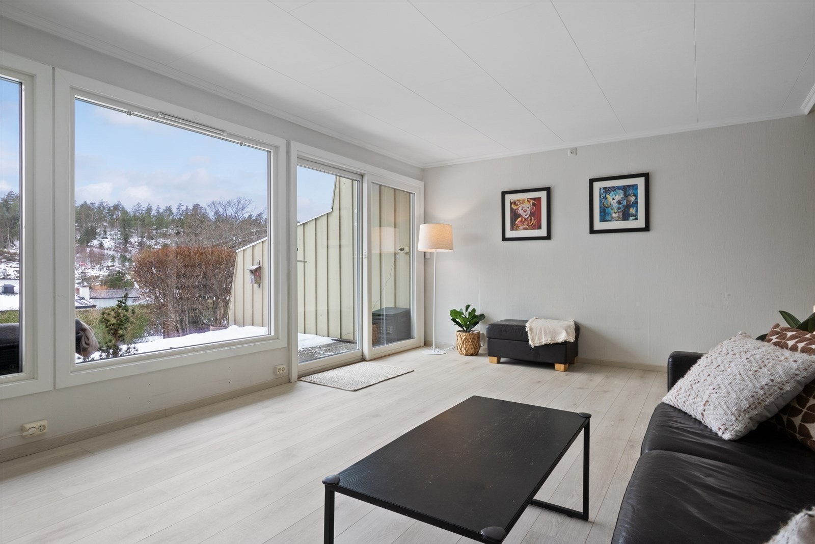 Stuen er i boligens 1.etasje, et lyst og innbydende rom med 1-stavs laminat fra 2023 på gulv og lyse slette vegger. Galleribilde