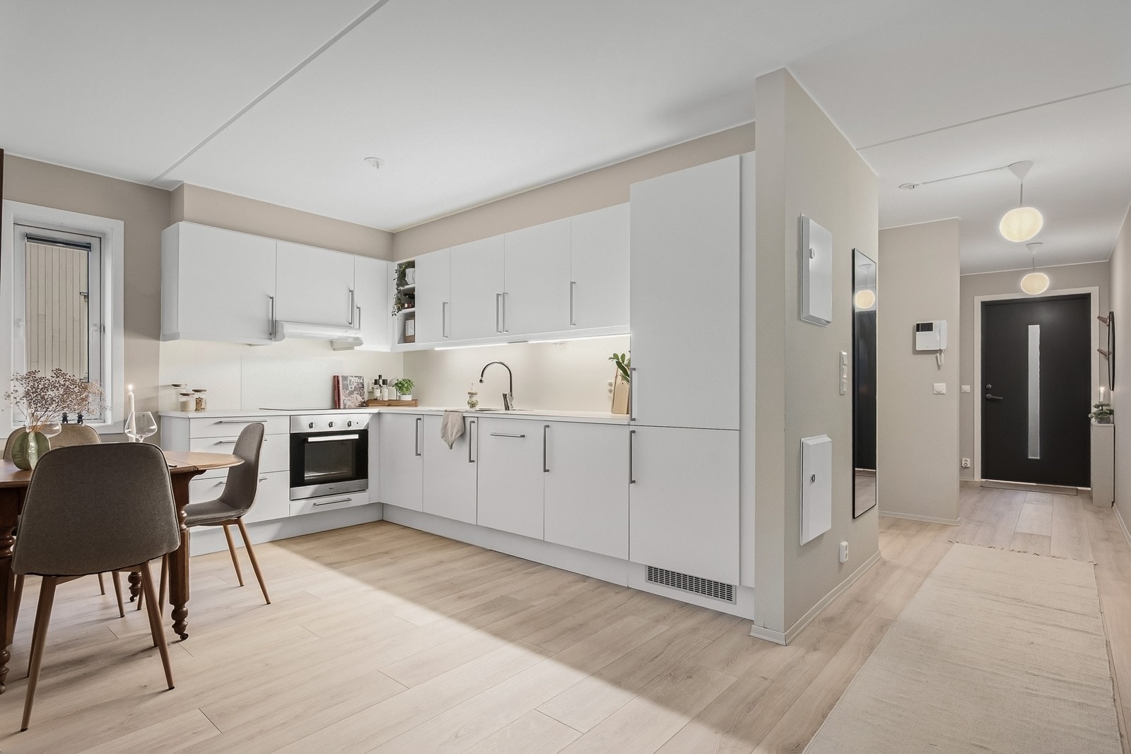 HTH kjøkkenet har en funksjonell L-formet planløsning med godt med skap- og benkeplass. Innredningen har slette fronter og laminat benkeplate. Integrerte hvitevarer består av komfyr, induksjonstopp, oppvaskmaskin samt kjøle- og fryseskap Galleribilde