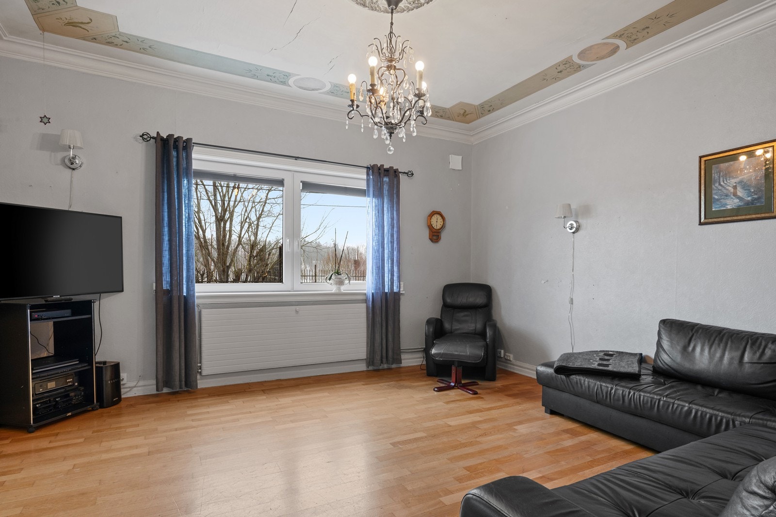 Klassiske detaljer som stukkatur og rosett i taket gir rommet karakter. Galleribilde