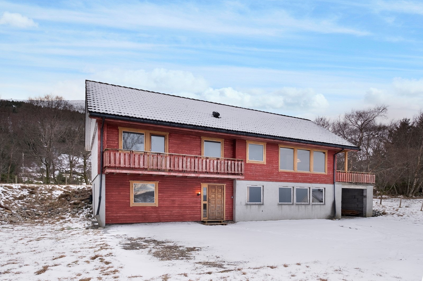 Boligen viser en inngangsdør i teak og flere vinduer med 3-lags glass. Galleribilde