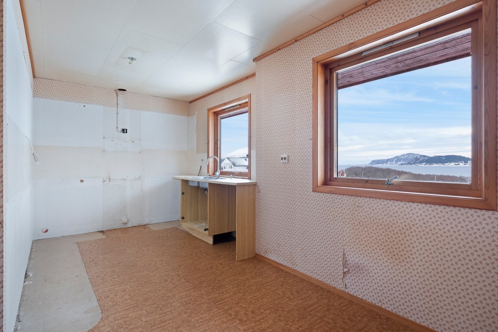 Rommet har store vinduer som gir godt lysinnslipp, men kjøkkeninnredningen er fjernet. Galleribilde