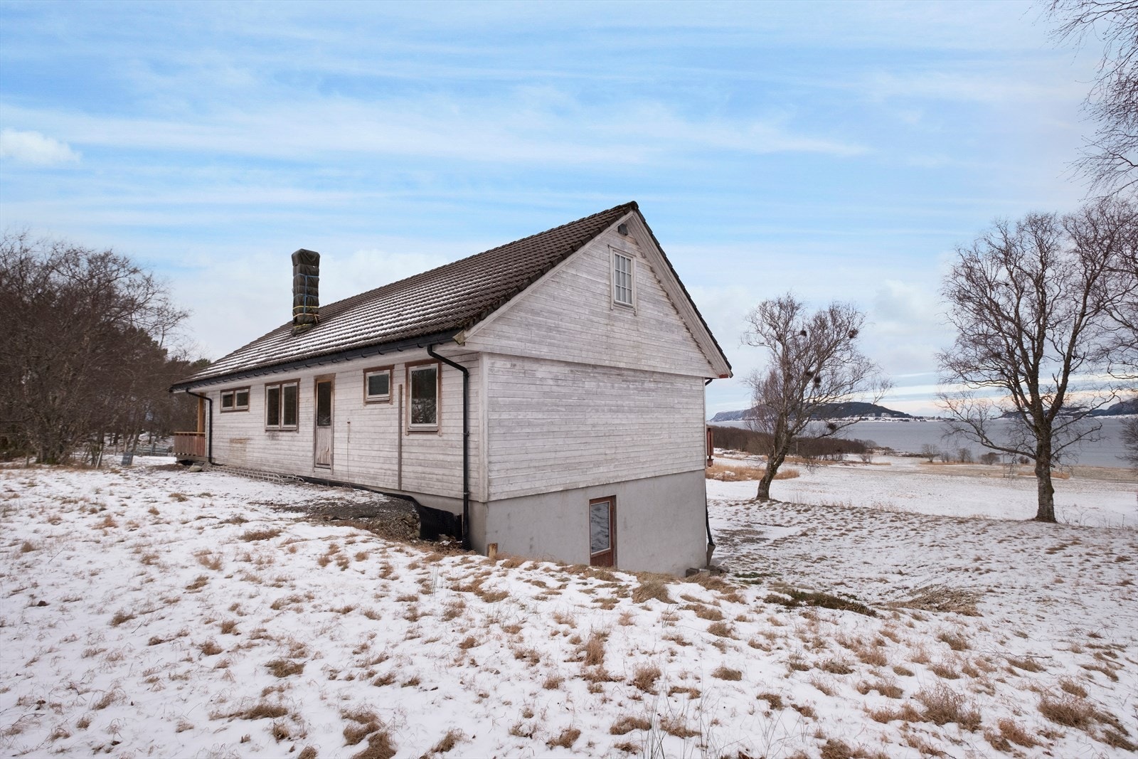 Veggen mot nord er malt og viser slitasje, med enkelte vinduer uten sprosser. Galleribilde