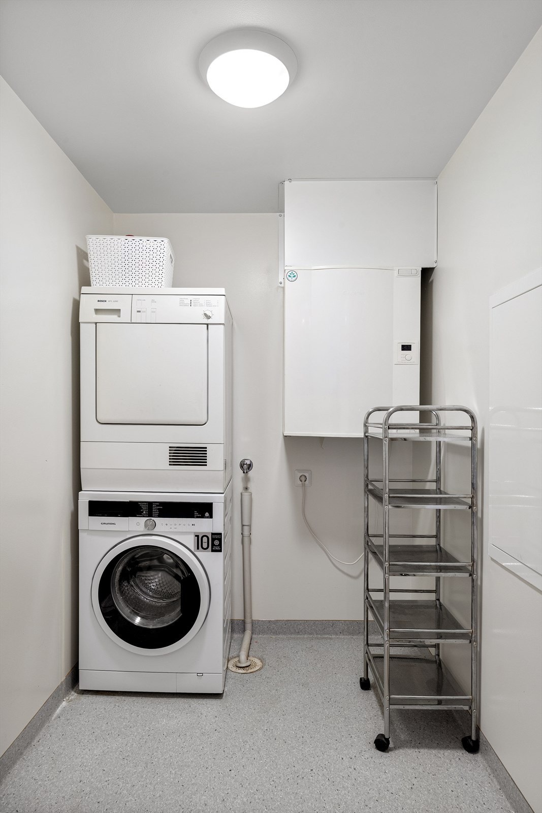 Funksjonelt vaskerom/bod med vinylbelegg, plastsluk og opplegg for vaskemaskin. Galleribilde