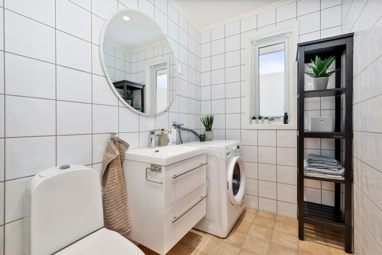 Badet er flislagt med elektrisk gulvvarme og funksjonell innredning. Galleribilde