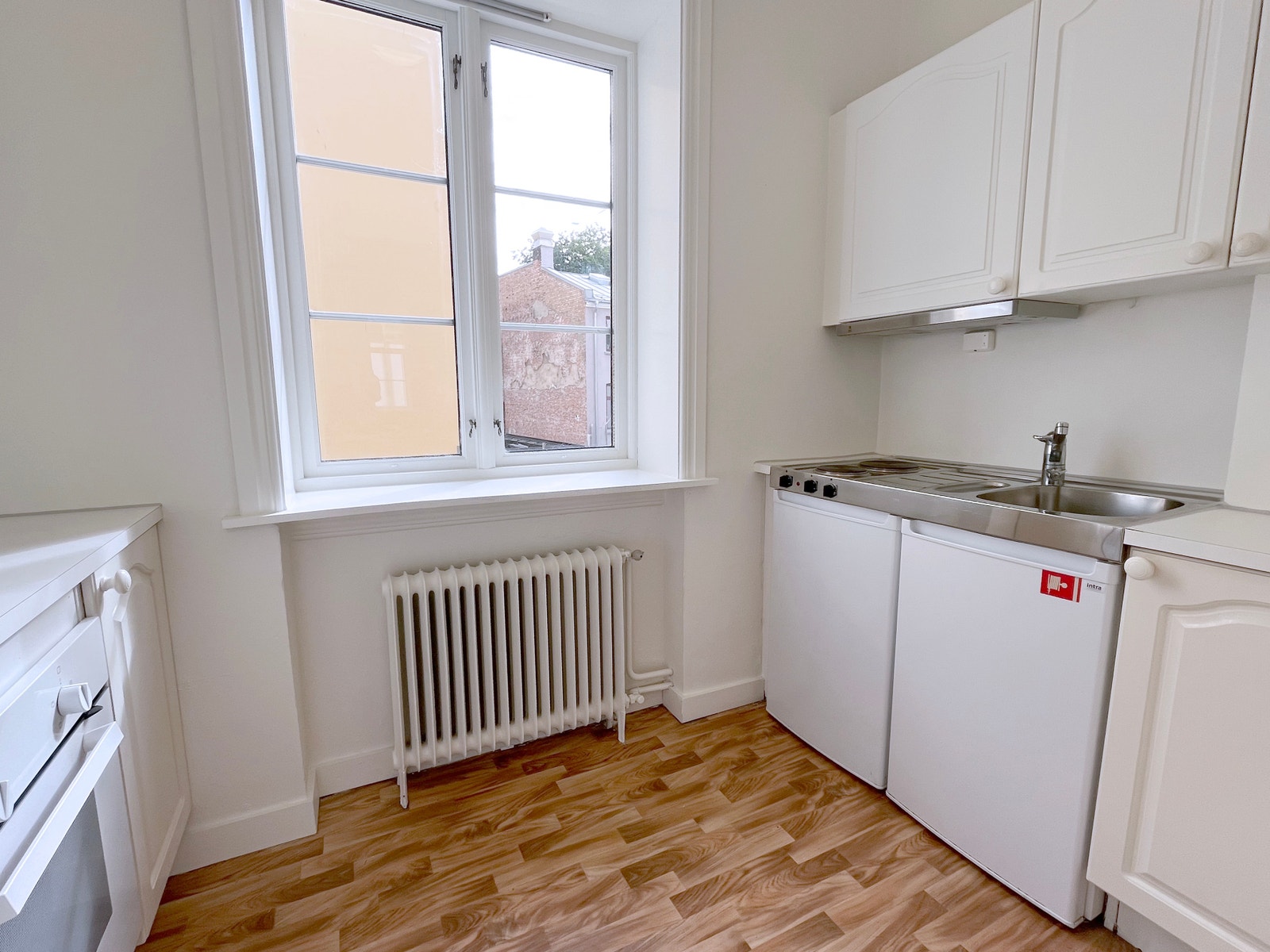 Kjøkken med hvitevarer. Komfyr, kokeplater og kjøleskap med frysedel. Galleribilde