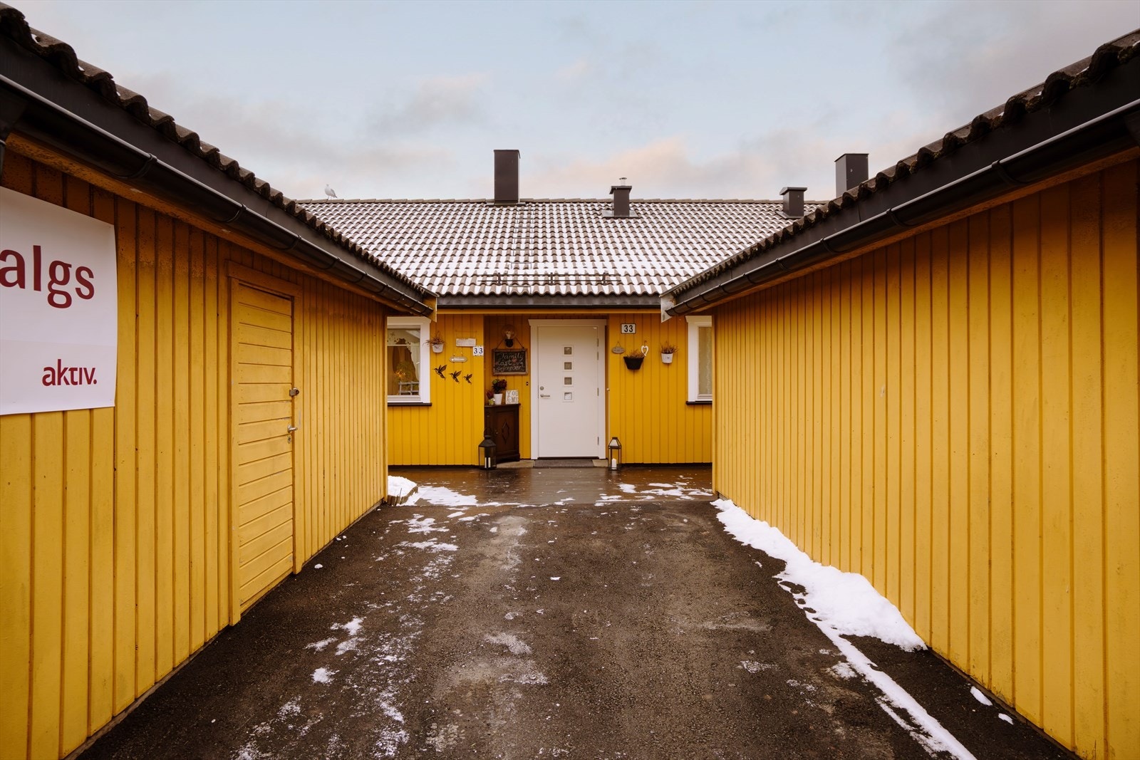 Innkjørsel og adkomst til boligen, med oversiktlig og lett tilgjengelig inngang. Garasjen er rett utenfor. Galleribilde