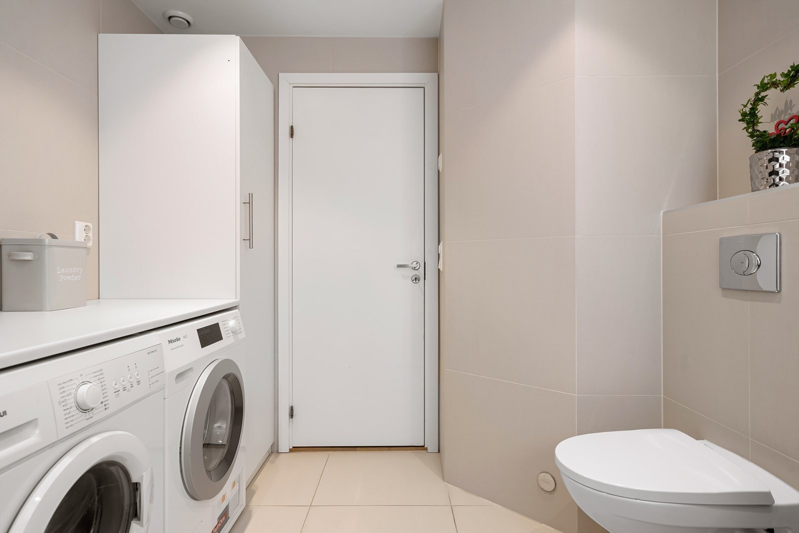 Praktisk løsning med opplegg for vaskemaskin og vegghengt toalett. Galleribilde