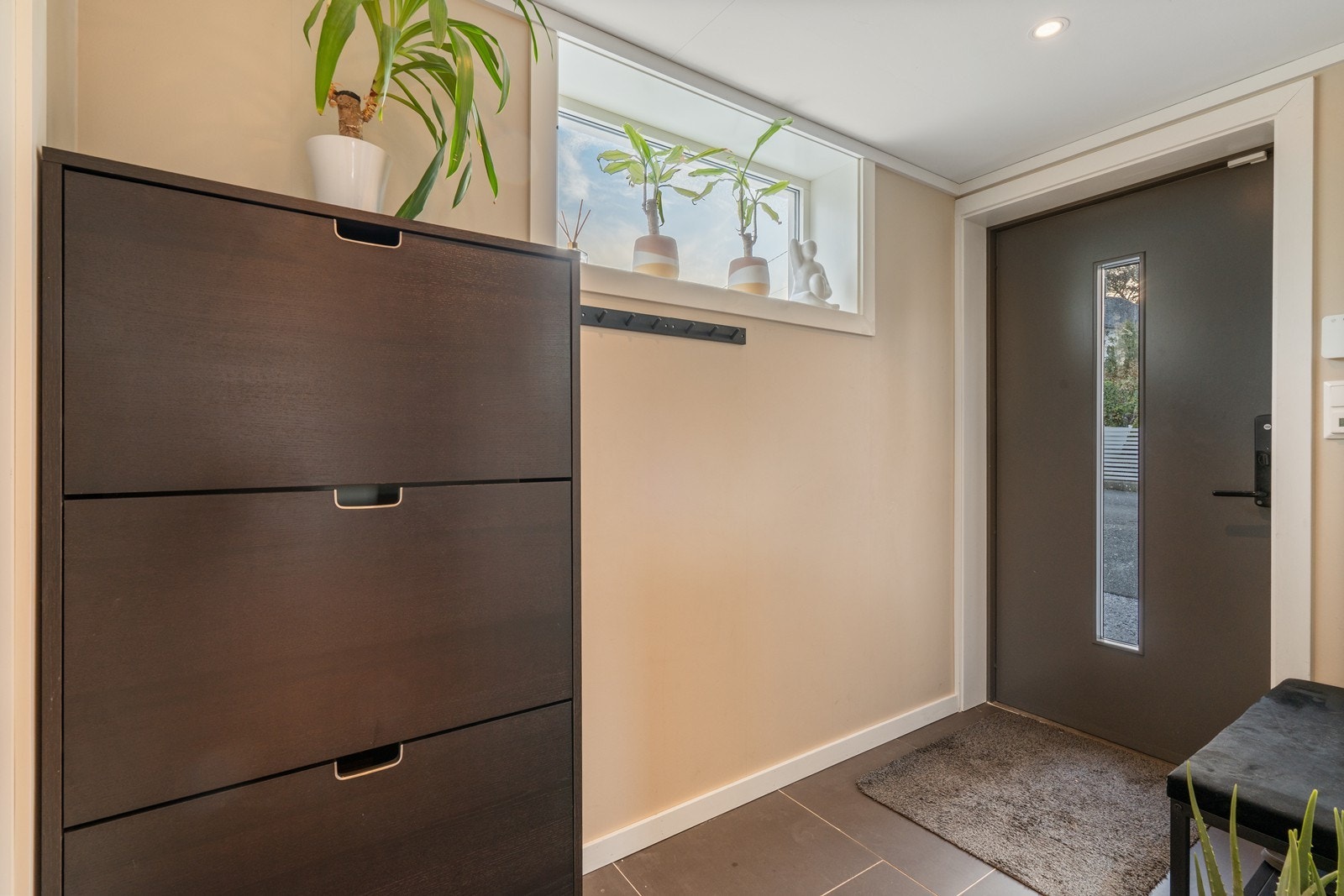 Du møtes av en romslig entrè med plass til oppbevaring av yttertøy og sko i stor skyvedørsgarderobe. Galleribilde